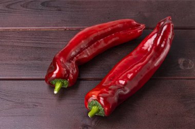 Ahşap arka planda izole edilmiş taze kırmızı biberin yakın görüntüsü. Sağlıklı yeme kavramı. 