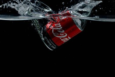 Suya düşen teneke kutunun yakın görüntüsü. Coca Cola. İsveç. Uppsala. 03.14.2020.