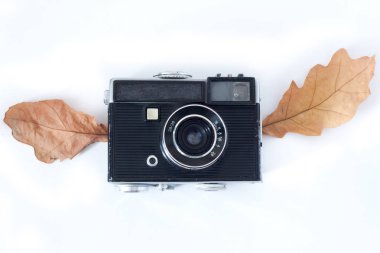 Vintage analog fotoğraf makinesi beyaz arka plan, üst görünümü üzerinde kuru akçaağaç yaprakları kanatlı .
