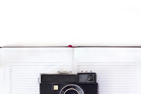 Vintage camera met riem en boek op witte achtergrond, bovenaanzicht . — Stockfoto