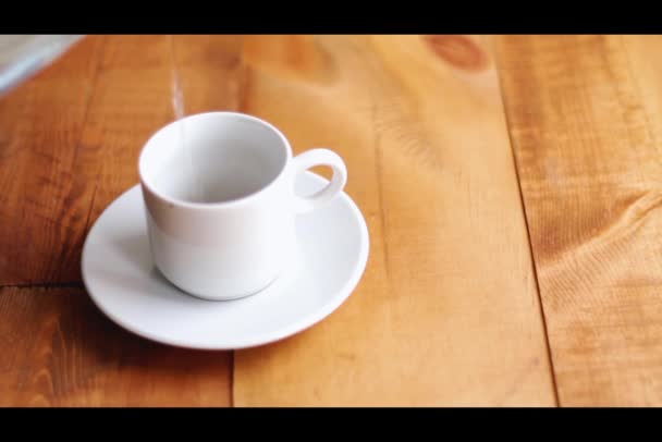 Cooking hot strong coffee in white ceramic cup on wooden background. Good morning concept — Stock Video