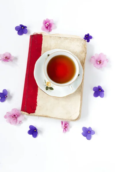 Xícara de chá no livro com flor sobre fundo wite  . — Fotografia de Stock