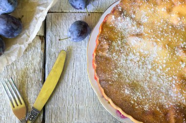 bıçak ve çatal Beyaz ahşap zemin üzerinde rustik erikli kek.