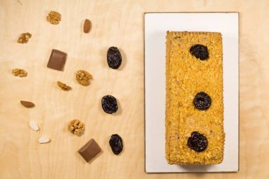 Ahşap arka plan üzerinde fındık ile bölünmüş lezzetli kuru erik kek