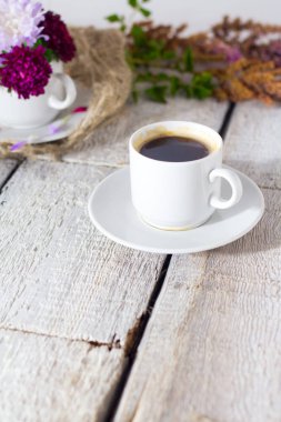 Romantik arka plan ile kahve, beyaz masa üzerinde çiçekler.