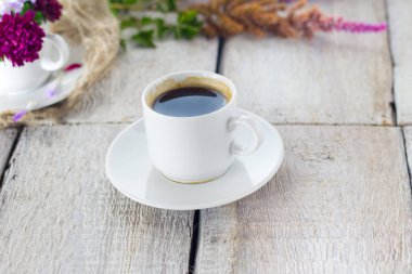 Çiçekler ve beyaz arka plan üzerine bir fincan kahve ile kompozisyon..