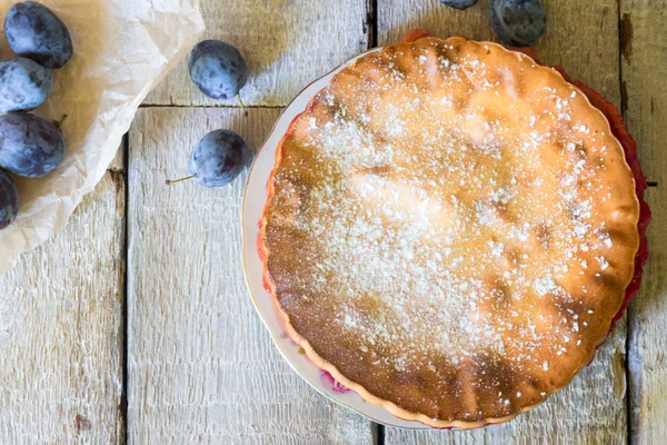 Tarta casera con ciruelas con tenedor en la mesa rústica blanca . —  Fotos de Stock