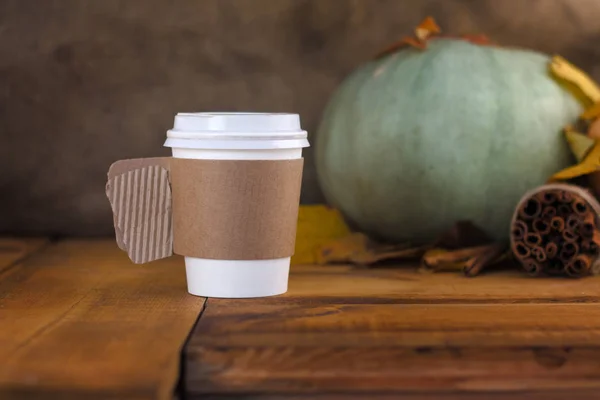 Fond d'automne avec feuilles sèches et tasse de café en papier chaud sur une table en bois — Photo