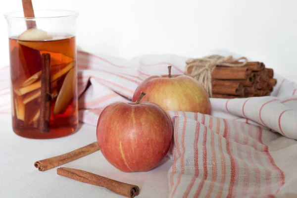 Natura morta, cibo e bevande. Bevanda calda autunnale in un bicchiere con frutta e spezie su fondo di legno bianco . — Foto Stock