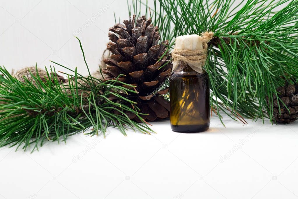 The cedar oil in a glass bottle on a white wooden background. Source of essential fatty acids for healthy nutrition.