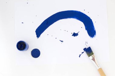 arka plan mavi şerit boyalar ve beyaz kağıt arka planda fırçalar boyalı.