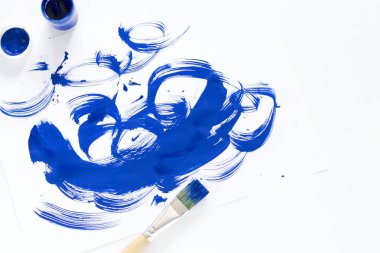 Suluboya boyalar, fırçalar ve kağıt, beyaz arka plan üzerinde bir su renk paleti yakın çekim