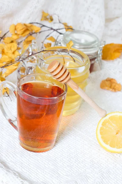 Primo piano di tazza di tè con foglie di tè, menta su sfondo vintage in legno. Tisana nera con limone, zenzero e miele. bevanda calda invernale — Foto Stock