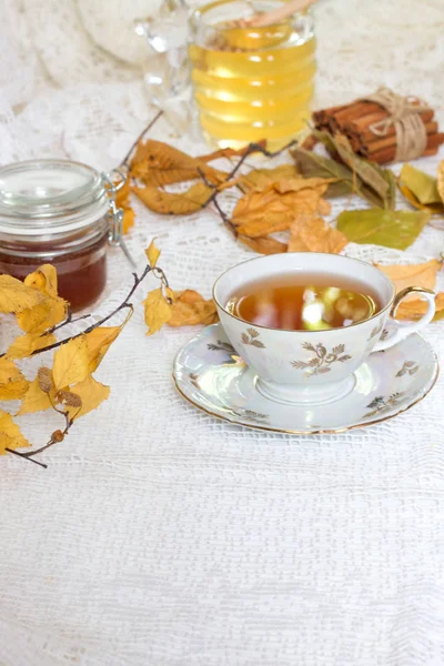 Thé sur fond romantique automne vintage avec du miel et des feuilles d'automne sur table blanche — Photo