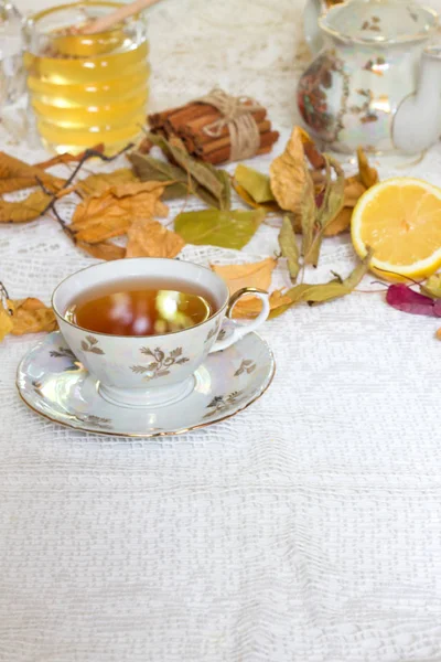 Xícara de chá quente e folhas de outono, na mesa de madeira . — Fotografia de Stock