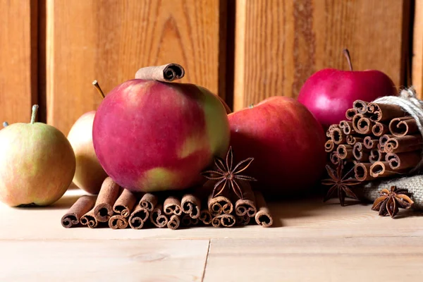 Färska röda och gröna äpplen, kanelstänger på trä bakgrund — Stockfoto