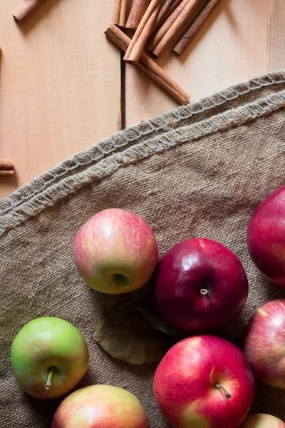 Röda äpplen på en trä bakgrund med säckväv. frukt, naturlig mat — Stockfoto