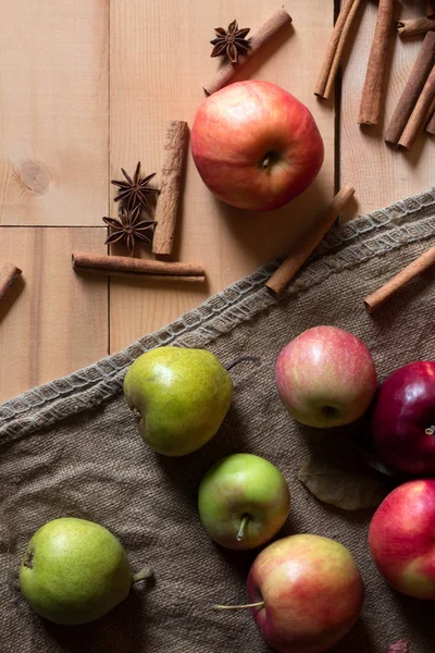 Röda och gröna äpplen på en trä bakgrund med säckväv. — Stockfoto