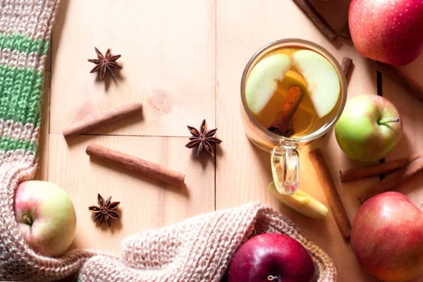 Hösten sammansättning av äpple te med kanelstänger, färska äpplen, varm halsduk på en trä bakgrund — Stockfoto
