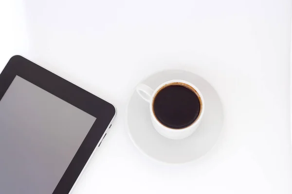 Цифровой планшет и чашка кофе на белом столе . — стоковое фото
