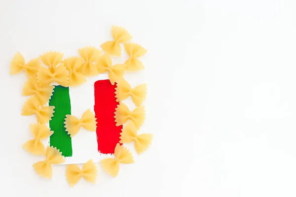 Miniatyr papper flagga Italien med pasta. Italienska flaggan pekaren på vit bakgrund. Med kopia utrymme. — Stockfoto