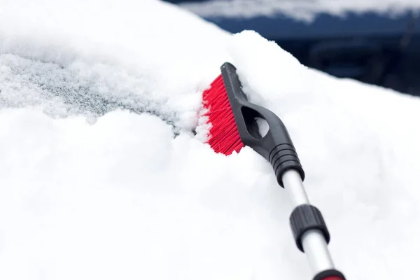 Invierno nevado en una ciudad en un día soleado. Coche después de las nevadas en el estacionamiento. Mujer joven tratando de abrir el coche helado  . —  Fotos de Stock