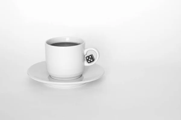 Une tasse de café avec des dés sur fond blanc — Photo