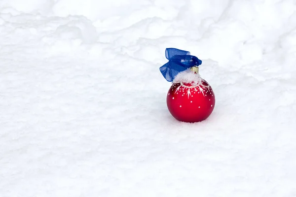 Natal brinquedo encontra-se no fundo da neve — Fotografia de Stock