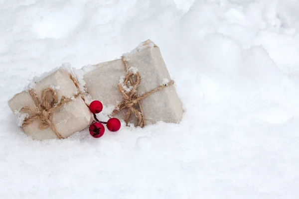 Caja de regalo con muérdago en nieve fresca sobre un fondo —  Fotos de Stock