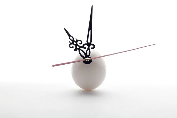 白い背景の上の卵と時計の針 ロイヤリティフリーのストック画像