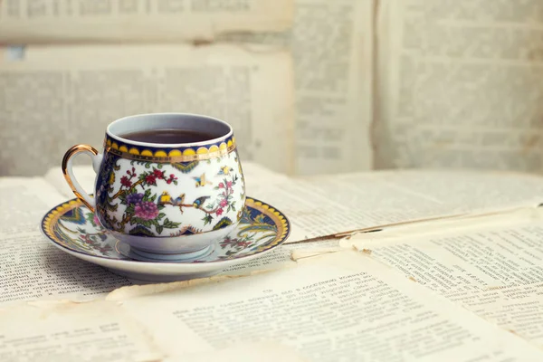 En gammal kopp kaffe på bakgrunden av gamla lakan från boken — Stockfoto