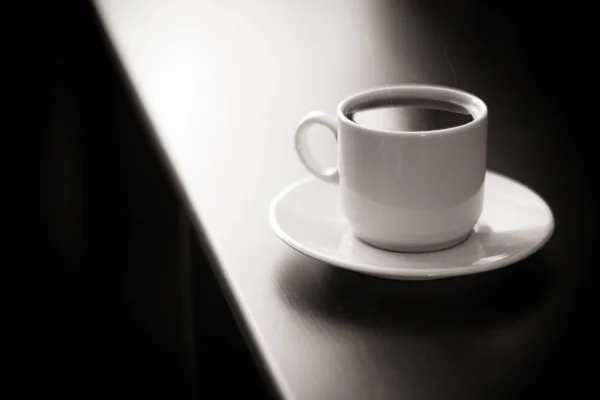 Cup of strong coffee on black table black and white photo. — Stock Photo, Image