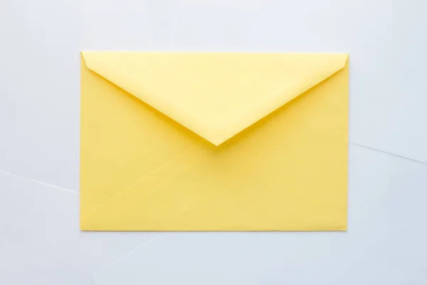 Желтый конверт на белом фоне — стоковое фото