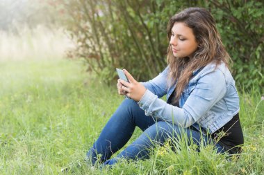 Genç kız açık havada akıllı telefon arıyor