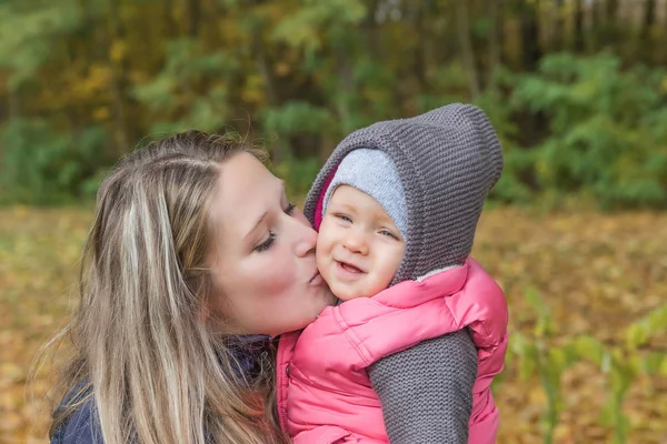 Joven madre está besando a su hija —  Fotos de Stock