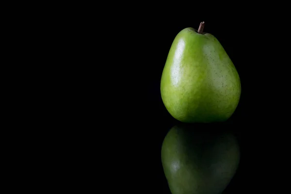 Reflejando la pera verde sobre un fondo negro — Foto de Stock