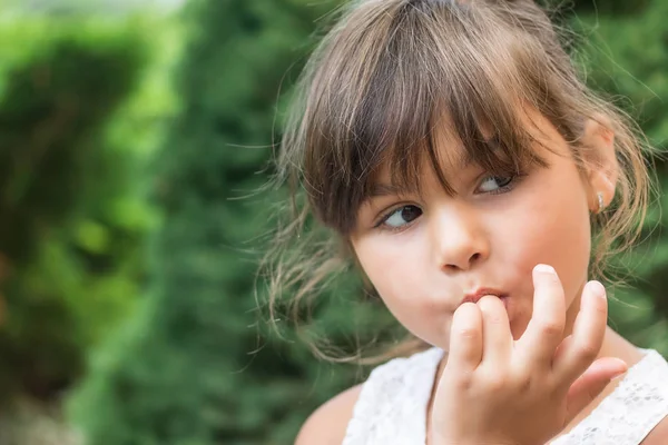 Little girl is licking her fingers — Stock Photo, Image