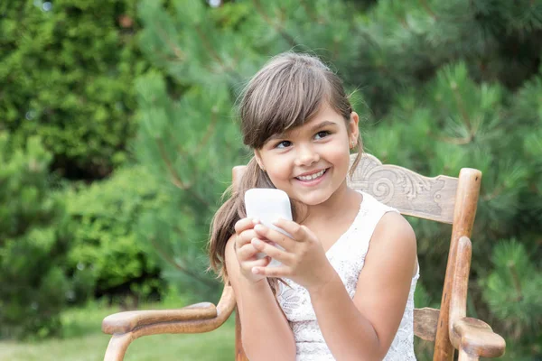 Sonriente morena niña con teléfono inteligente al aire libre —  Fotos de Stock