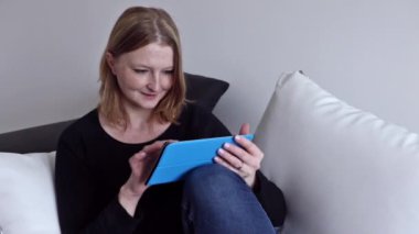 Genç kadın tablet kullanırken ifadeleri değişiyor