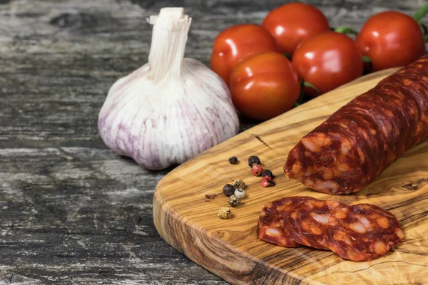 Sliced hot sausage Chorizo and vegetable on the wooden desk — Stock Photo, Image