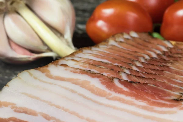 Closeup pohled na nakrájené slaninu, rajčata a polovinu česnekové žárovky. — Stock fotografie