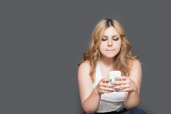 Teenager-Mädchen blickt konzentriert auf ihr Smartphone — Stockfoto
