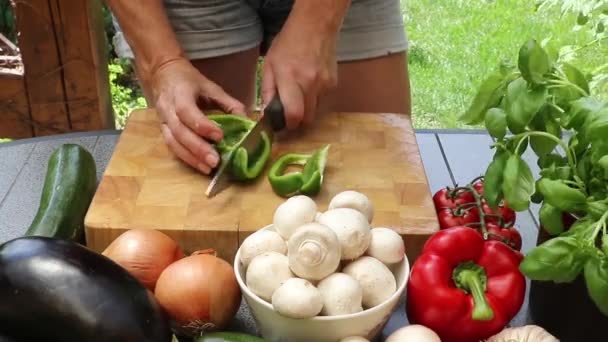 Mujer cortando pimiento verde en una tabla de madera — Vídeo de stock