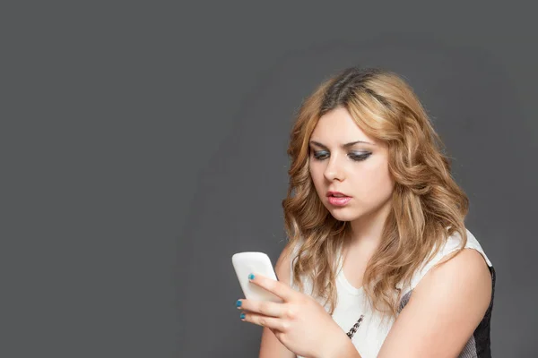 Sério adolescente menina concentricamente olhando para seu telefone inteligente — Fotografia de Stock