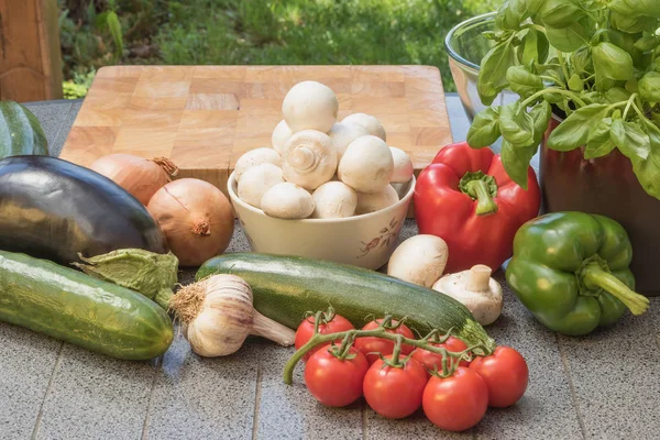 野菜は屋外の木製机の上の切断のため準備ができています。. — ストック写真