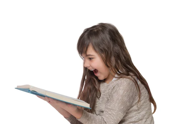 Skrattar lite flicka lutad över en öppen bok — Stockfoto