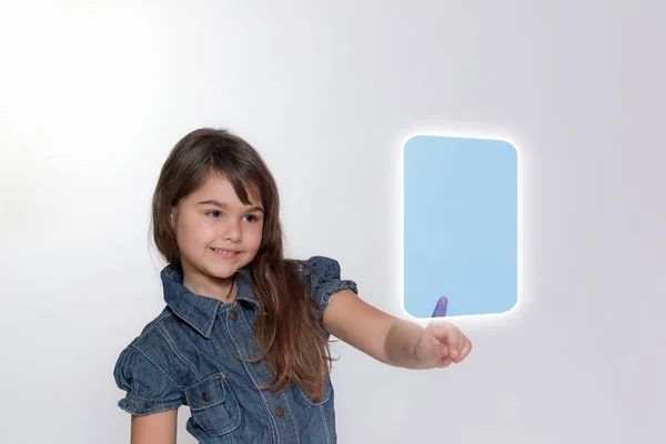 Sonriente niña está tocando rectángulo transparente por su tipo — Foto de Stock