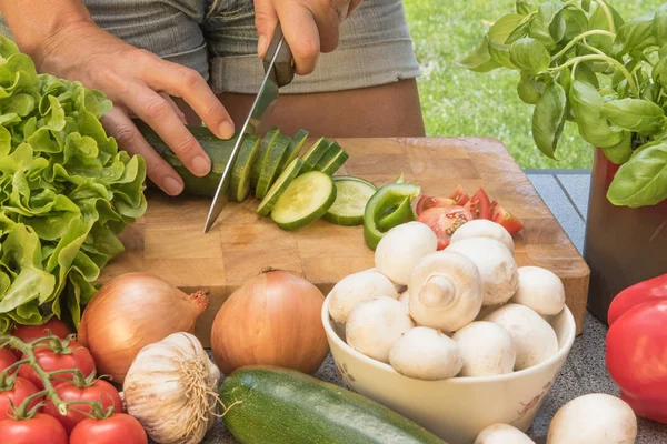 Vista frontal de cortar un pepino en una tabla de madera —  Fotos de Stock