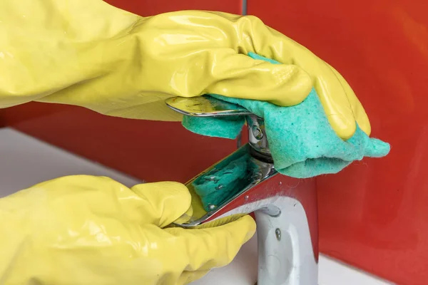 The housewife is cleaning a faucet in the bathroom — Stock Photo, Image