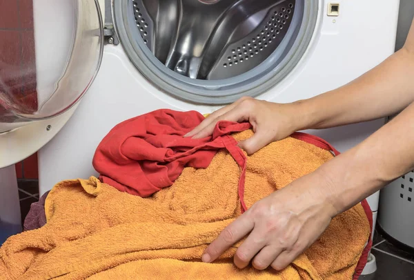 Руки домохозяйки готовы положить грязное белье в стиральную машину — стоковое фото